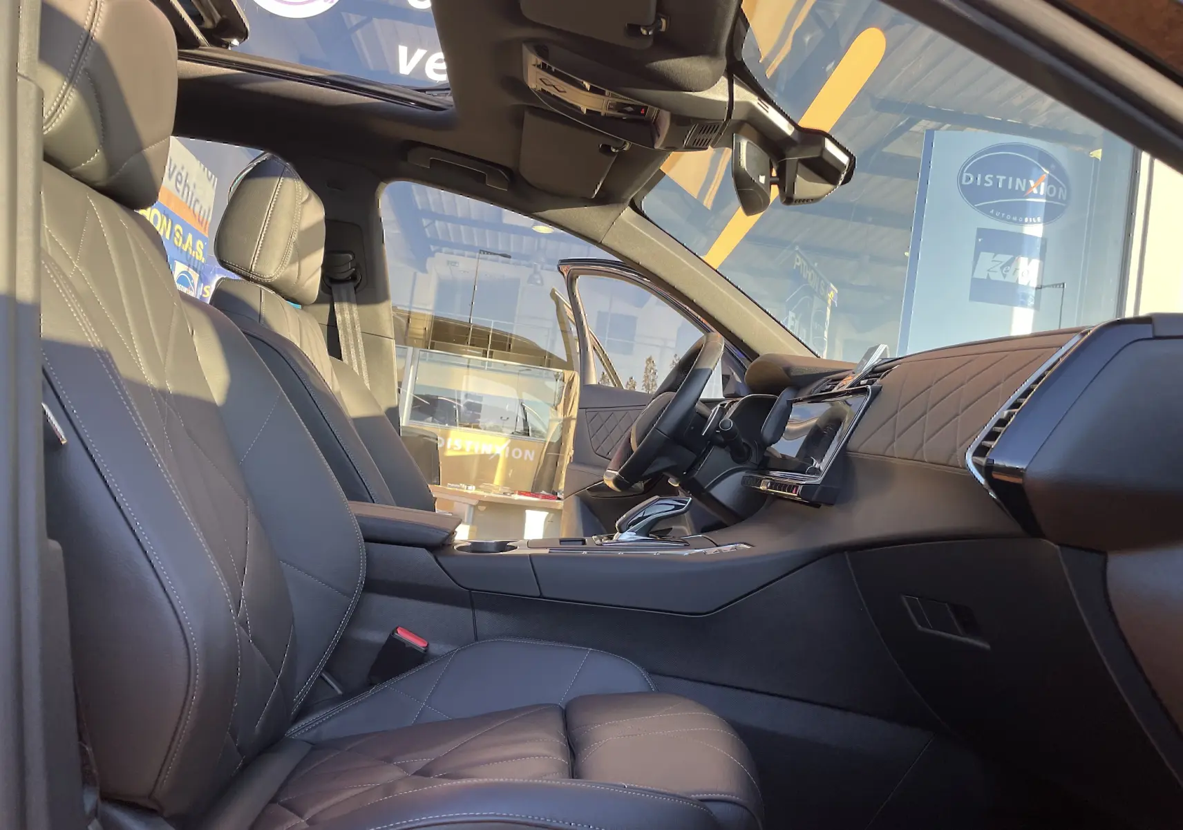 Vue intérieure côté conducteur du DS7 2024 avec sièges en cuir noir matelassé et tableau de bord moderne.