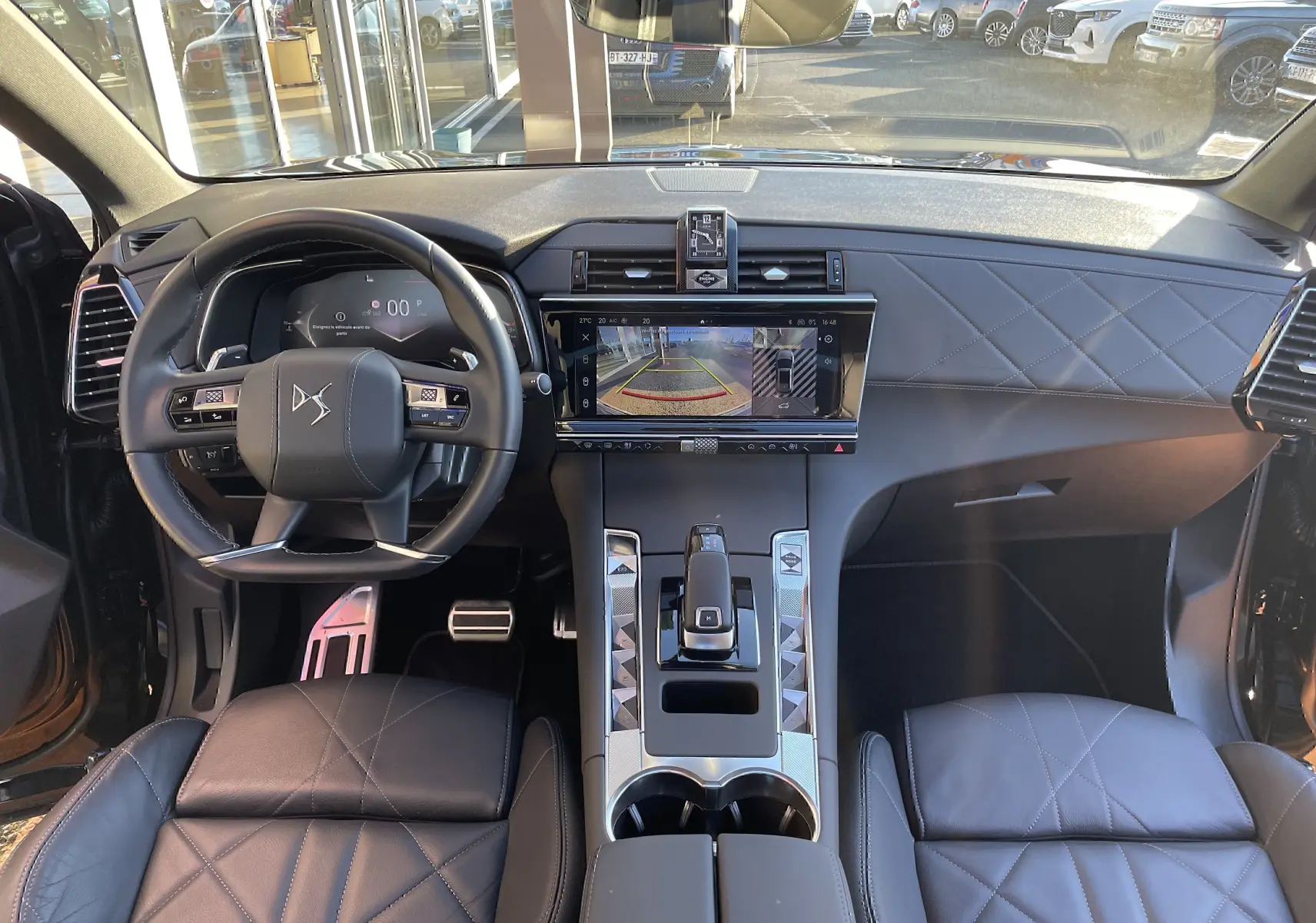 Intérieur du DS7 2024 noir Perla Nera, vue frontale du tableau de bord avec écran tactile et volant cuir noir.