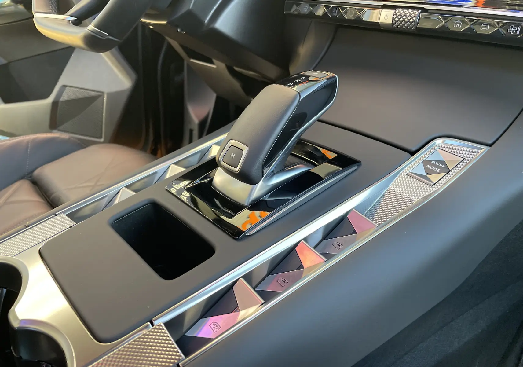 Gros plan sur la console centrale du DS7 2024 noir Perla Nera, mettant en valeur le levier de vitesse automatique et les commandes Drive Mode.