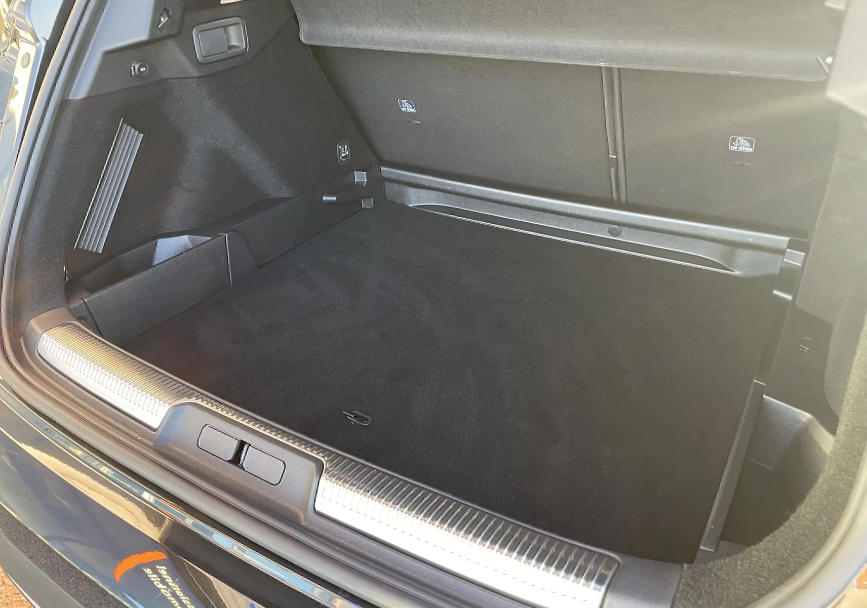 Coffre ouvert du DS7 1.5 BLUEHDi 130 noir Perla Nera, montrant un espace de chargement propre et bien fini.