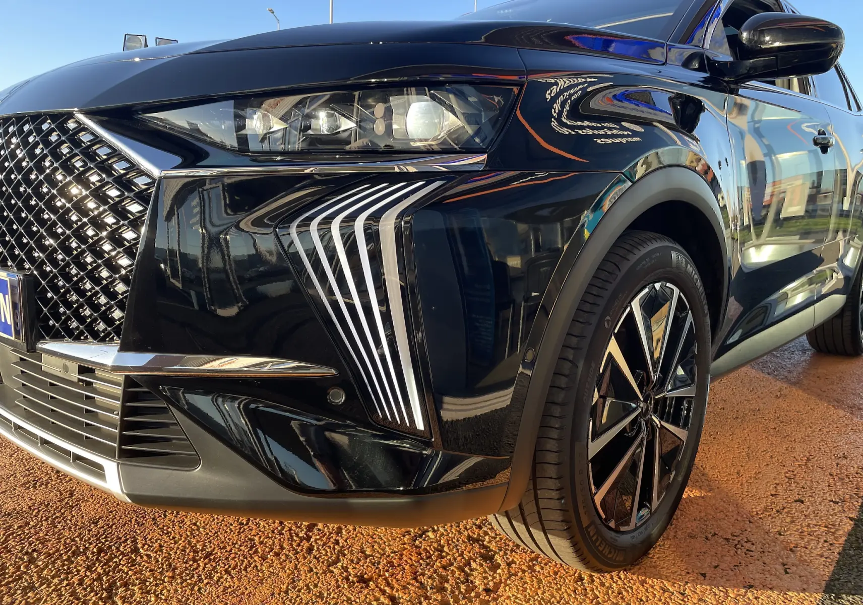 Vue de 3/4 avant droit du DS7 noir Perla Nera mettant en valeur la calandre distinctive et les feux DS Pixel Led Vision 3.0.