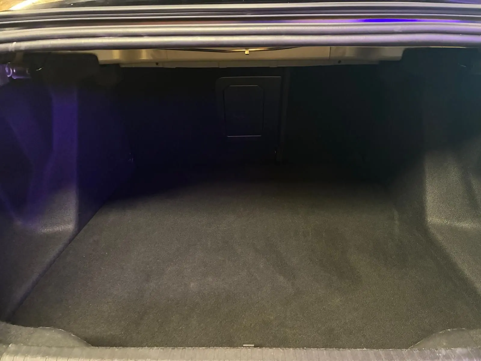 Coffre ouvert de la Citroën C4 X 1.5 BlueHDi 130 gris 2024, montrant un espace de chargement vide et propre.