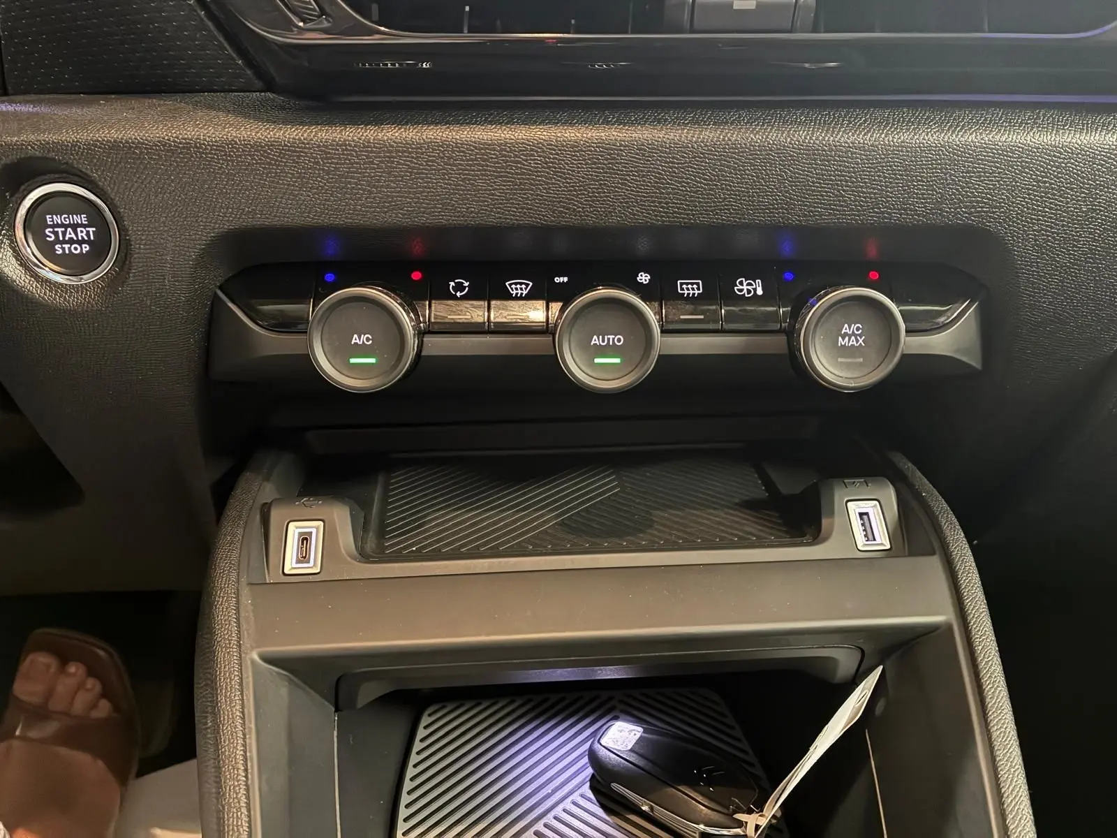 Gros plan sur la console centrale du Citroën C4 X gris 2024, montrant les commandes de climatisation et ports USB.