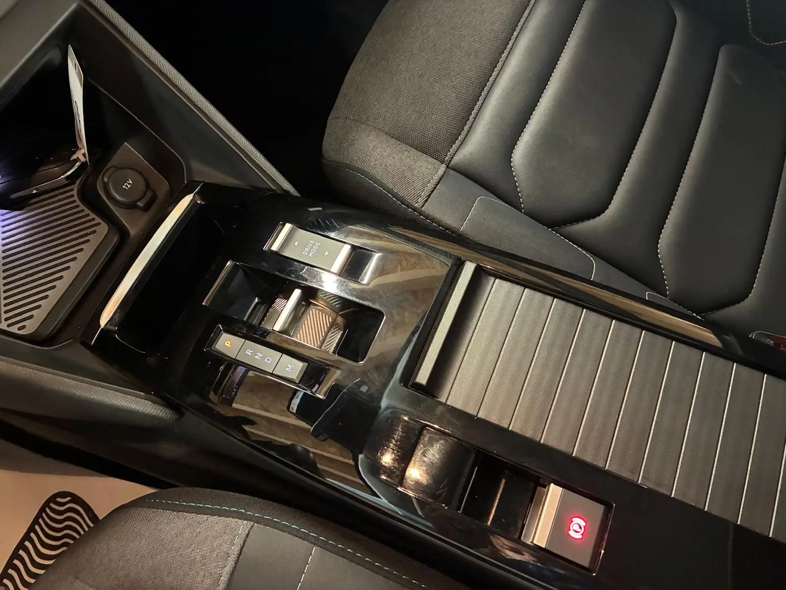 Vue rapprochée de la console centrale noire brillante et du siège tissu gris-noir de la Citroën C4 X 1.5 BlueHDi 130 2024.