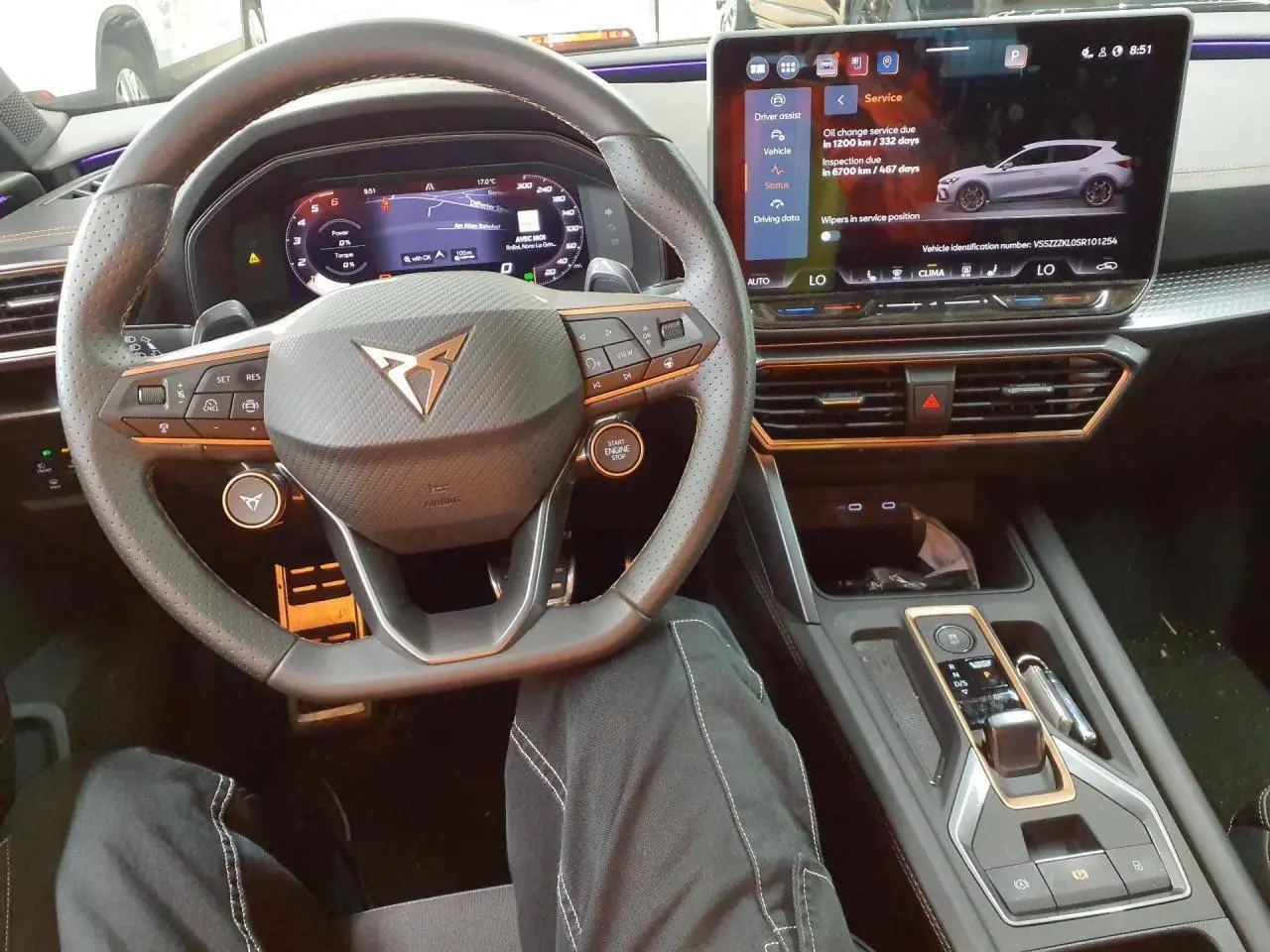 Vue intérieure centrée sur le volant cuir perforé CUPRA et l'écran tactile digital du tableau de bord.