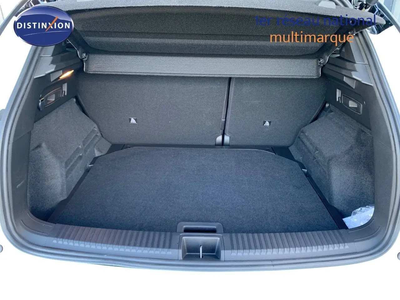 Coffre ouvert du Renault Austral blanc métal avec toit noir, vue arrière montrant un espace de chargement spacieux et propre.