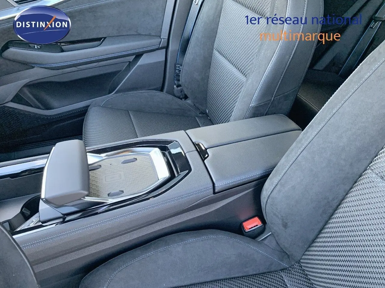 Intérieur du Renault Austral 2024, vue rapprochée de la console centrale et des sièges en tissu noir avec surpiqûres bleues.