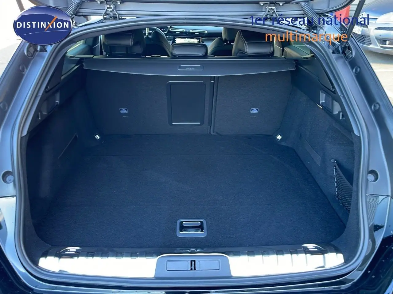 Coffre ouvert vu de l'arrière d'une Peugeot 508 SW noire, montrant un espace de chargement spacieux et propre.