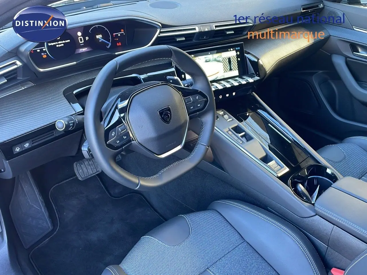 Intérieur moderne de la Peugeot 508 SW 2024, vue côté conducteur sur le tableau de bord et volant cuir noir.