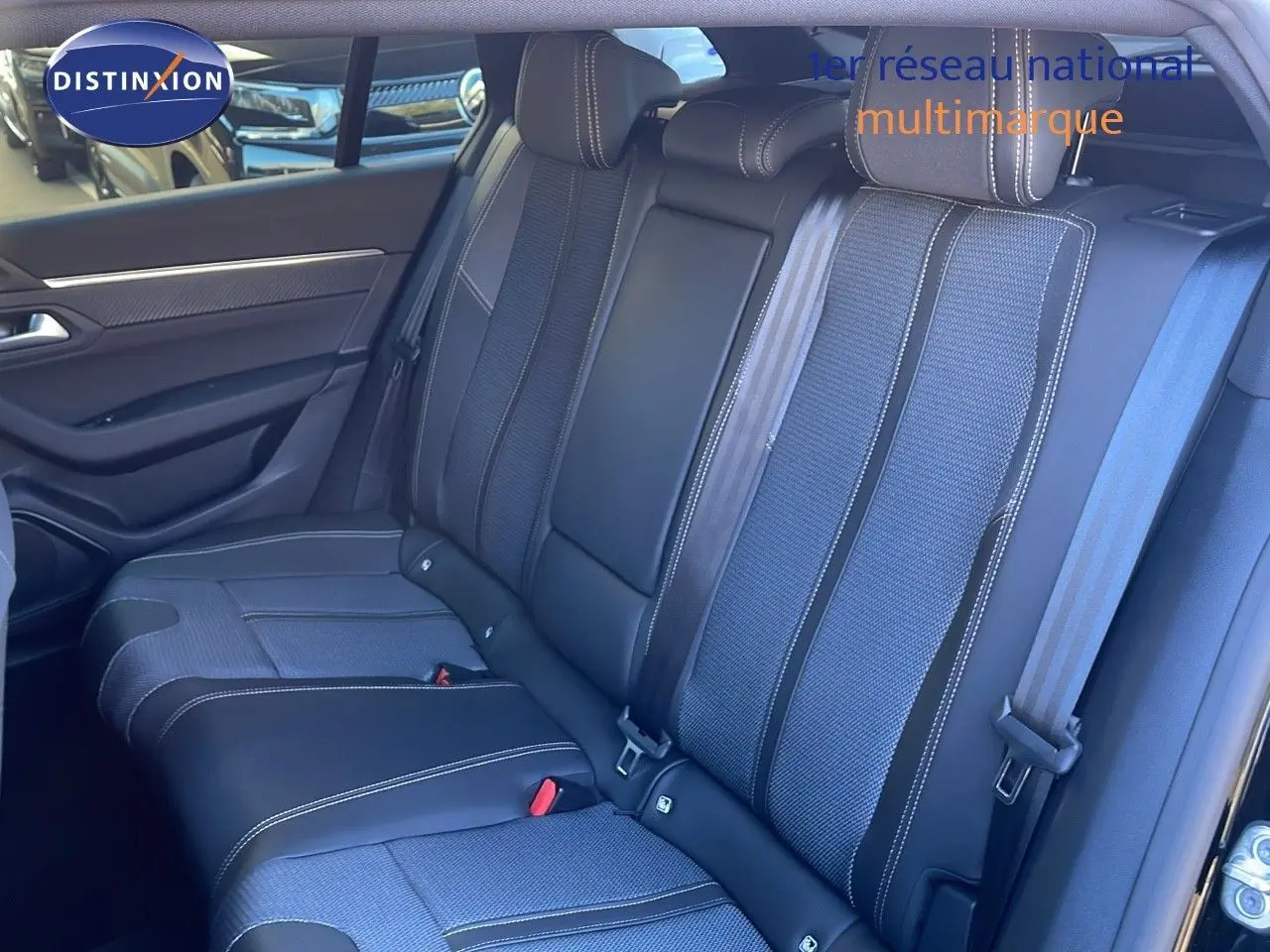 Vue intérieure côté gauche des sièges arrière en cuir noir et tissu gris du Peugeot 508 SW noir Perla Metal 2024.
