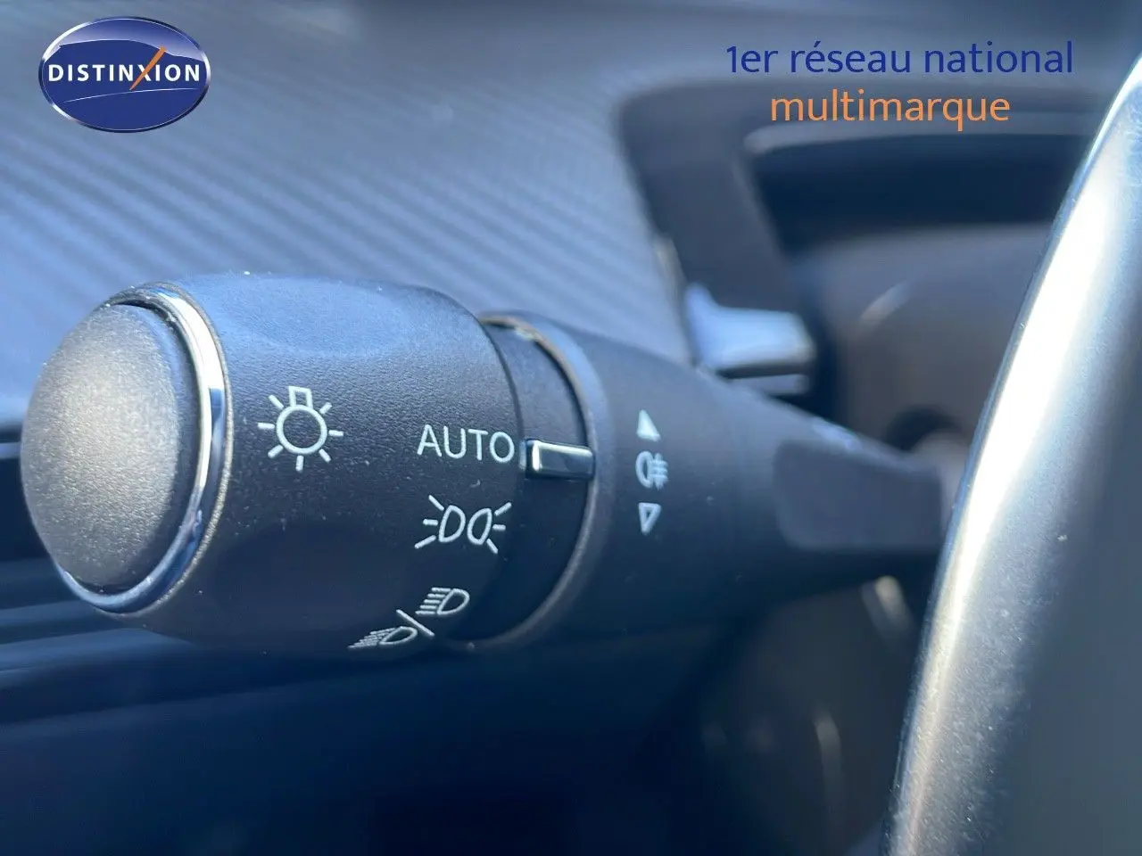 Gros plan sur la commande des phares de la Peugeot 508 SW noire, située à gauche du volant dans l'habitacle.