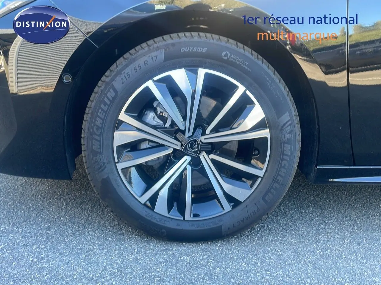 Gros plan sur la roue avant droite de la Peugeot 508 SW noire Perla Metal avec jante alliage bicolore.