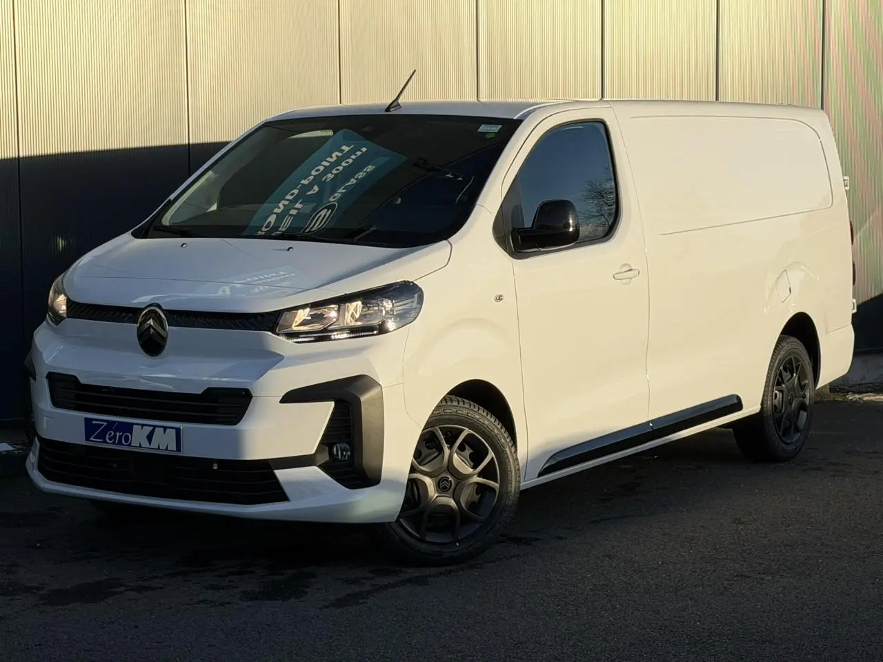Vue 3/4 avant droit d'un utilitaire Citroën Jumpy XL blanc Icy avec coques de rétroviseurs noires et jantes foncées.