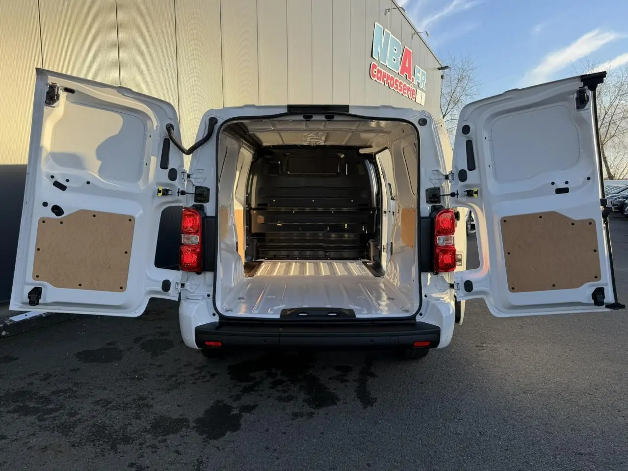 Vue arrière du Citroën Jumpy XL blanc Icy avec portes ouvertes révélant la grande zone de chargement vide.