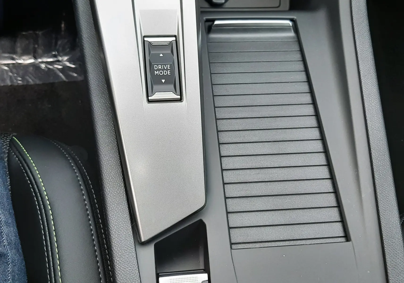 Vue rapprochée de la console centrale noire avec bouton Drive Mode et frein à main électrique rouge sur Peugeot 308 Hybrid 2025.