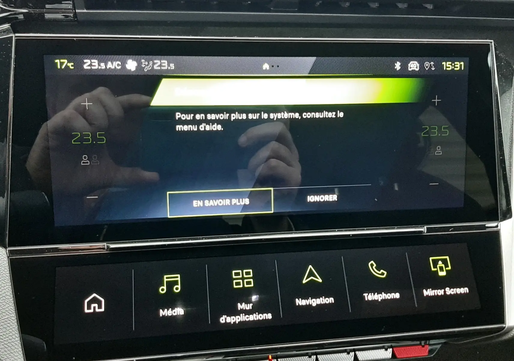 Écran tactile central de la Peugeot 308 1.2 Hybrid 145ch GT, affichant le menu d'aide et les commandes multimédia.