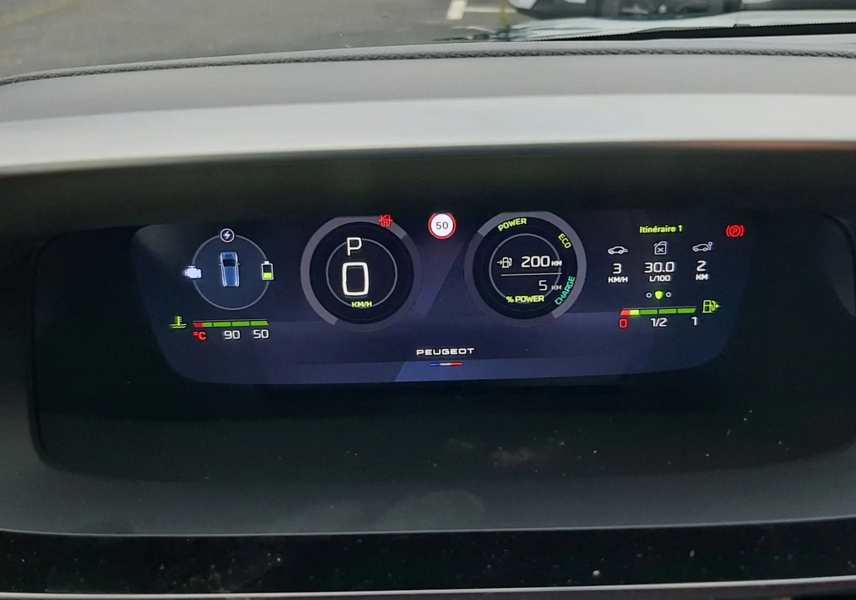 Tableau de bord numérique de Peugeot 308 hybride 2025 affichant vitesse, autonomie et indicateurs de conduite en vue frontale.