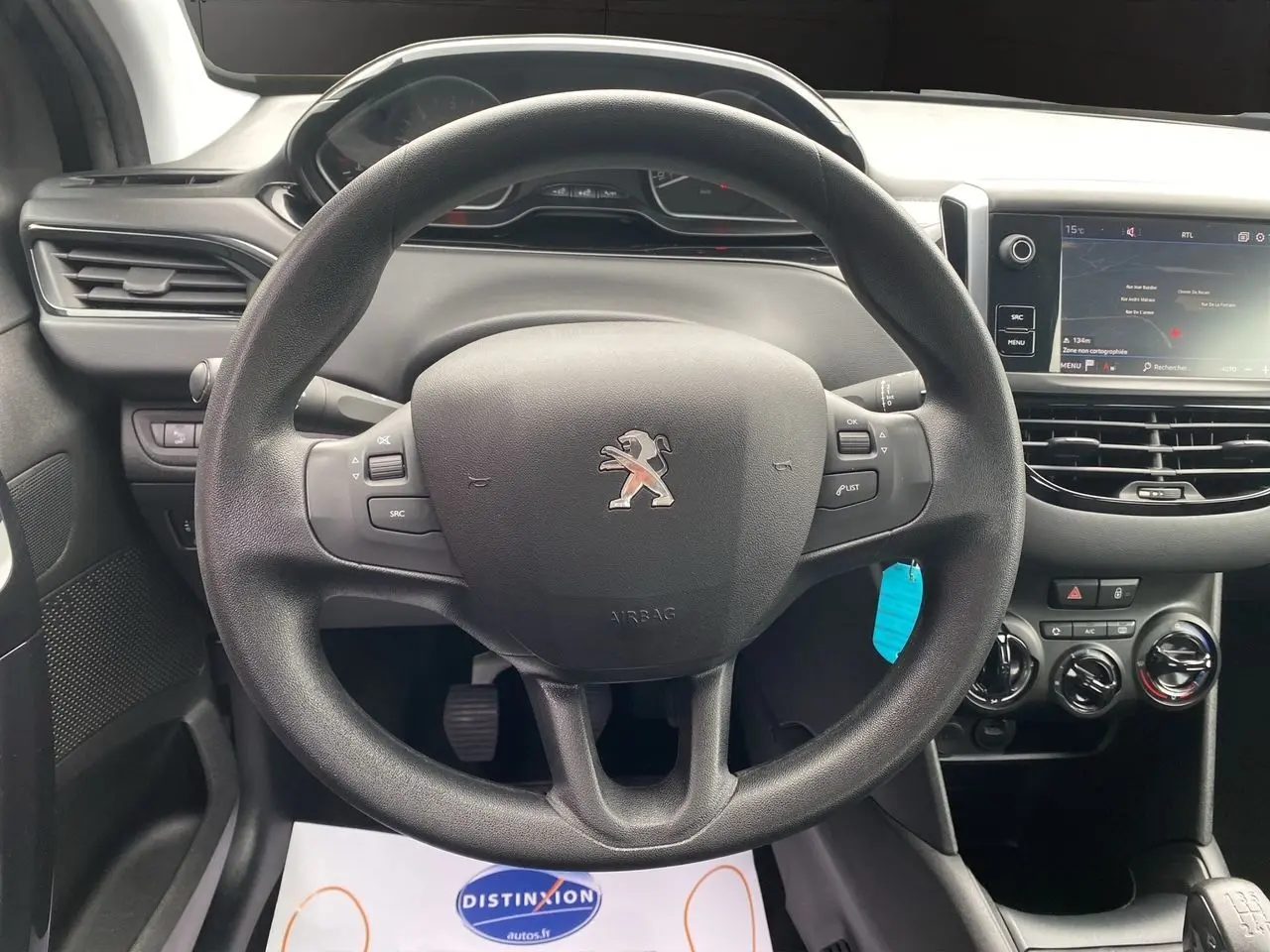 Vue centrée sur le volant noir de la Peugeot 208 AFFAIRE 2019 avec tableau de bord et écran GPS visible.