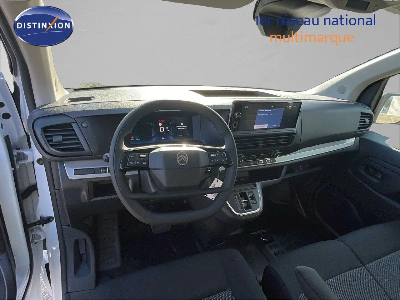 Vue intérieure du poste de conduite du Citroën Jumpy Fourgon blanc Kaolin, avec tableau de bord numérique et écran tactile central.