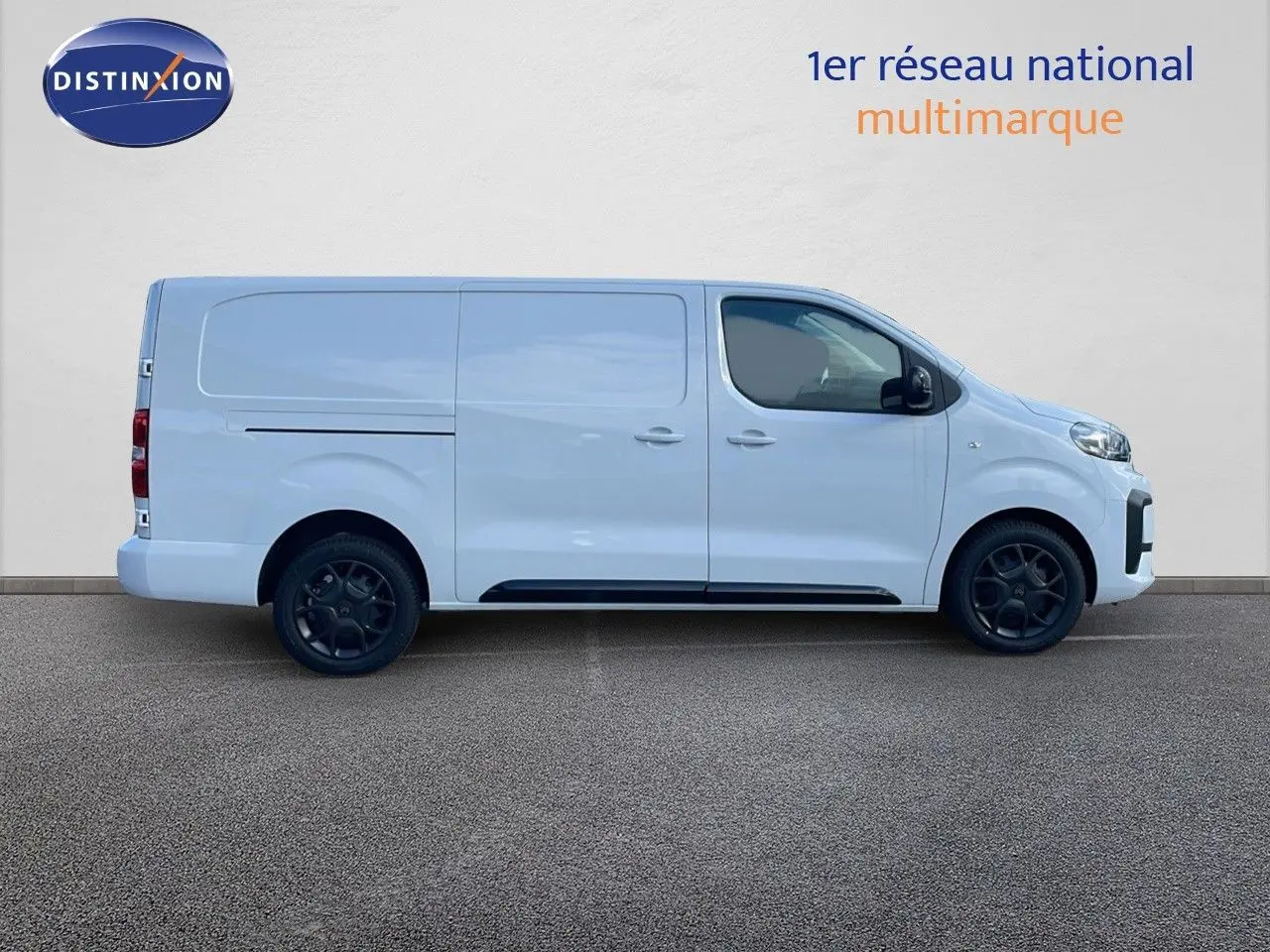 Profil droit d'un Citroën Jumpy Fourgon XL blanc Kaolin avec jantes noires et portes coulissantes arrière visibles.