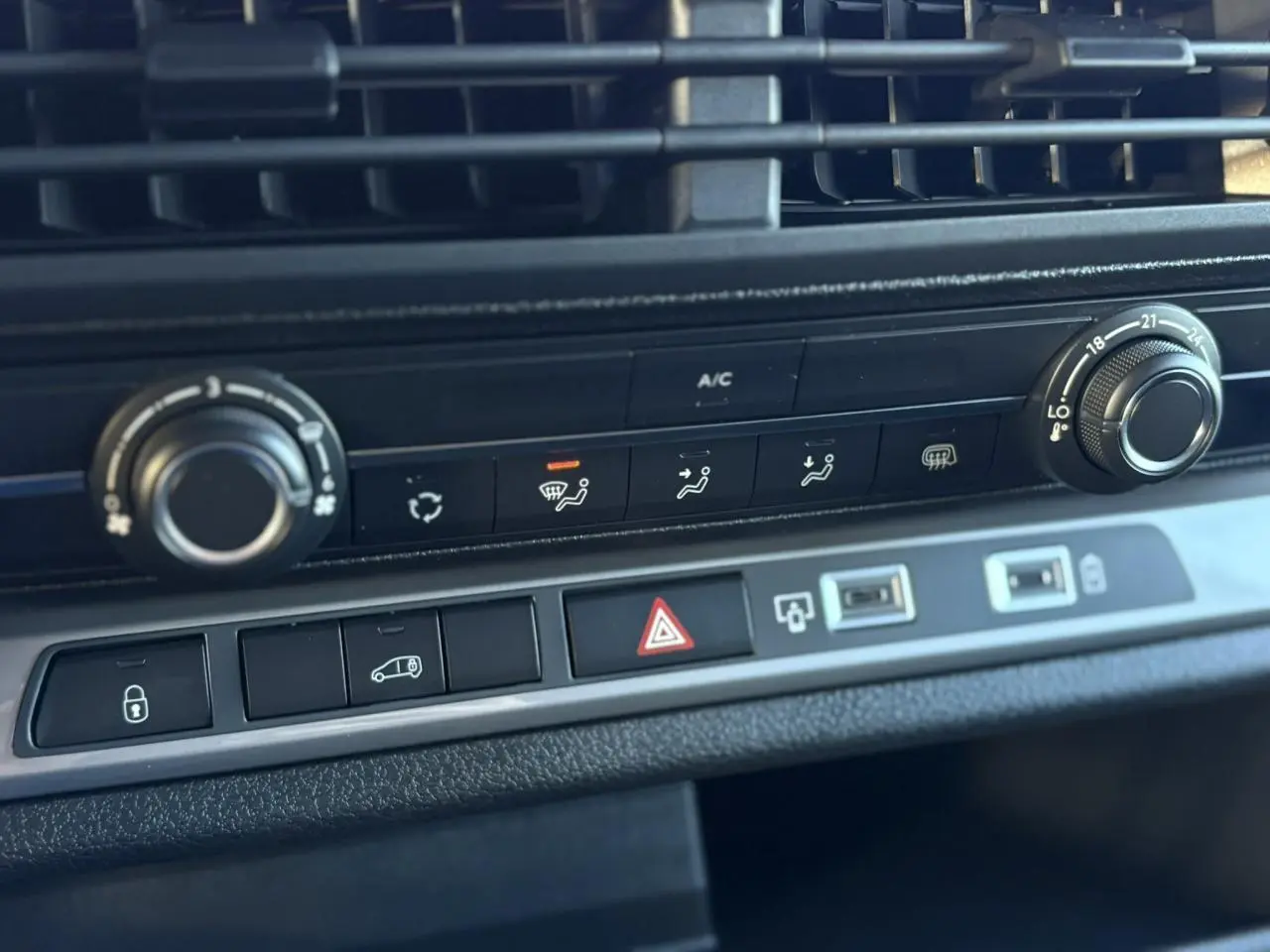 Gros plan sur la console centrale du Citroën Jumpy XL gris Titane, montrant les commandes de climatisation et les boutons de sécurité.