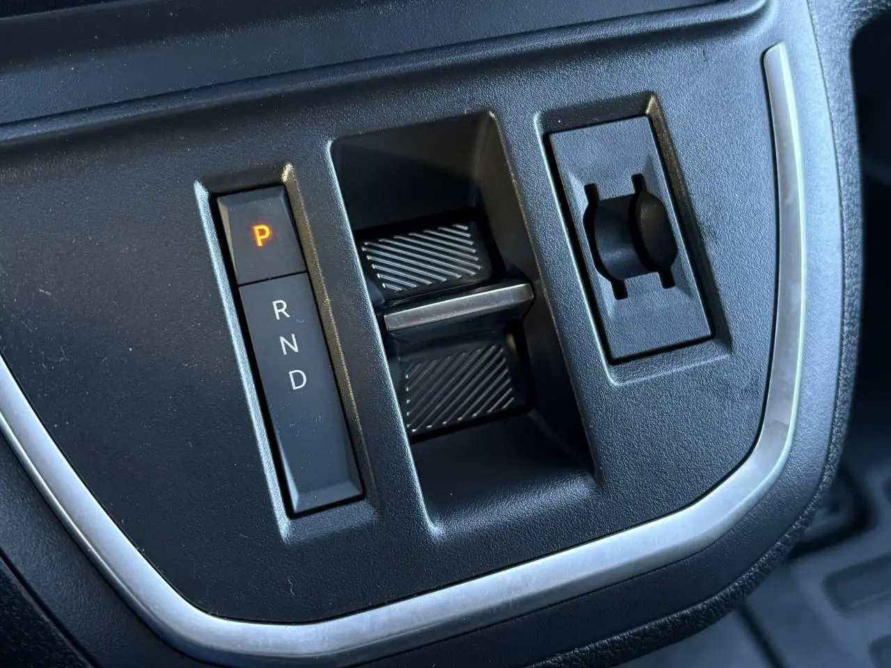 Gros plan sur la commande de boîte automatique noire du Citroën Jumpy XL gris Titane, avec levier en position parking.