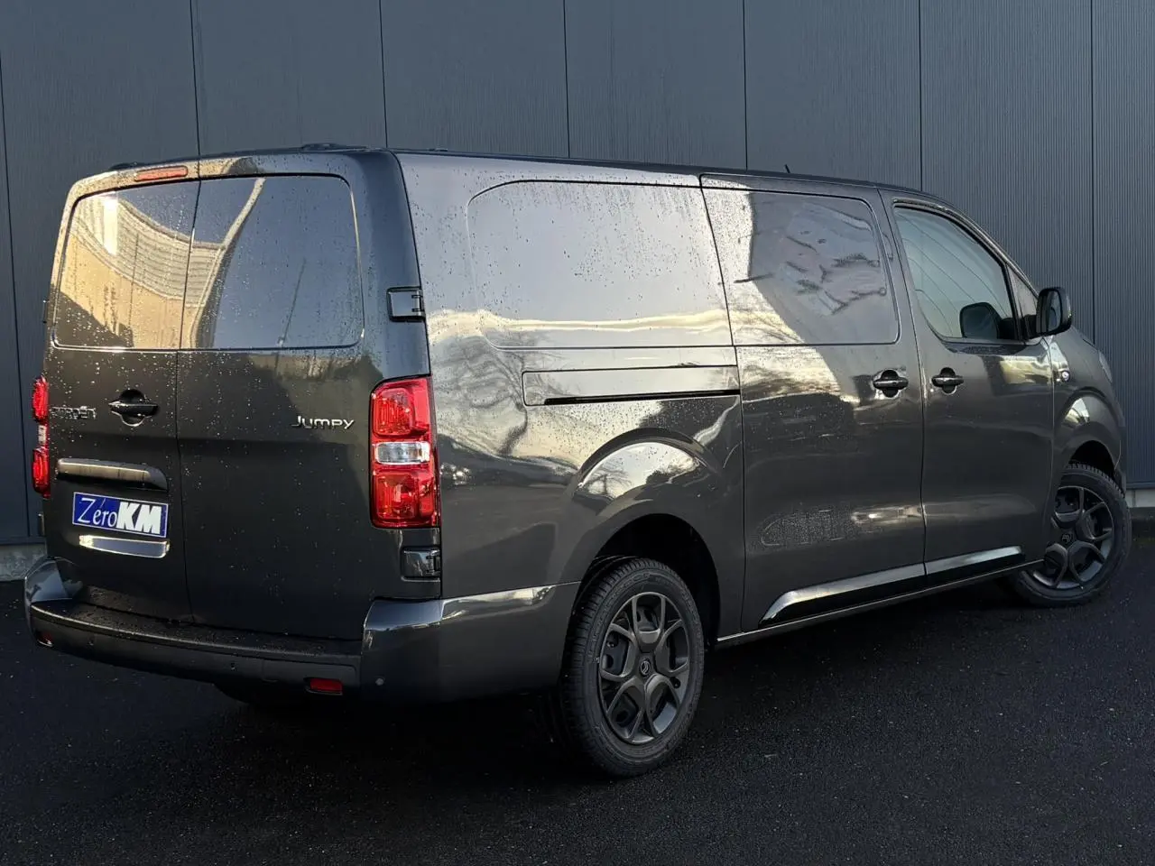 Vue 3/4 arrière droite d'un Citroën Jumpy XL gris titane avec pack look et jantes noires mate.