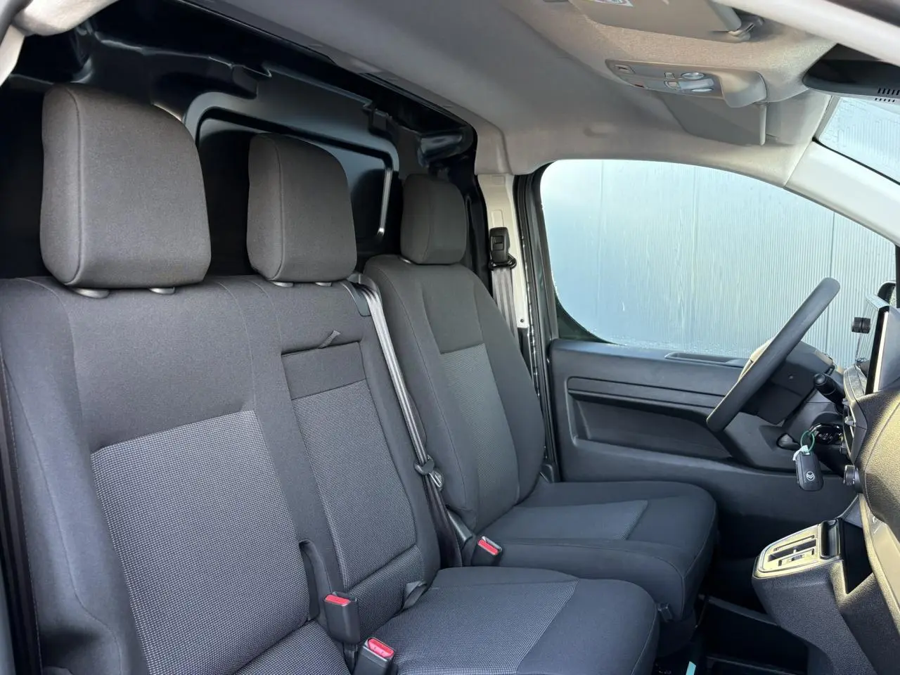 Intérieur du Citroën Jumpy XL 2025 vu côté droit, montrant la banquette passager 2 places en tissu gris foncé.