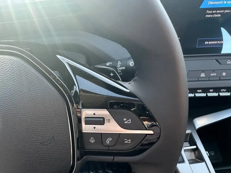 Gros plan sur les commandes au volant de la Peugeot 308 2025, finition Style, avec boutons multifonctions noirs et argentés.