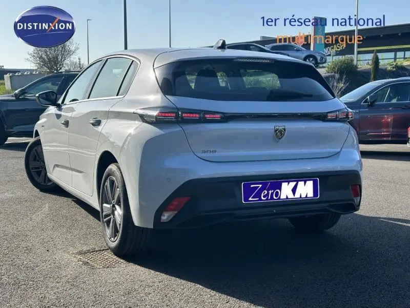 Vue 3/4 arrière droite d'une Peugeot 308 bleu clair avec feux arrière LED et jantes alliage.