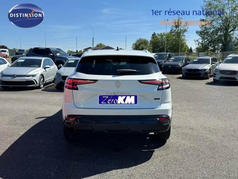 Vue arrière d'un Renault Austral rouge flamme 2025 avec feux arrière LED et barres de toit visibles.