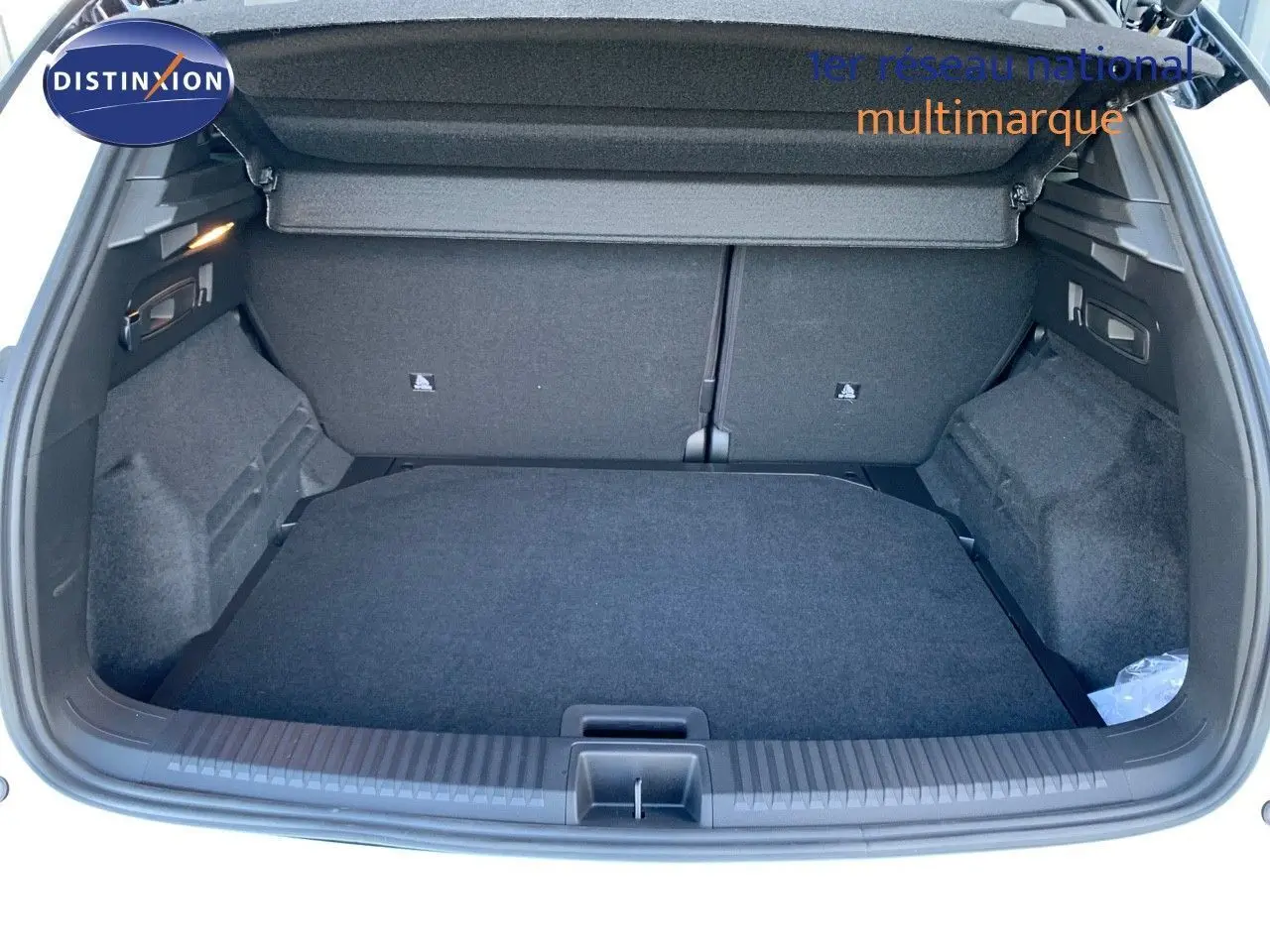 Coffre ouvert d'un Renault Austral 2024 blanc métal avec toit noir, montrant un espace de chargement propre et spacieux.