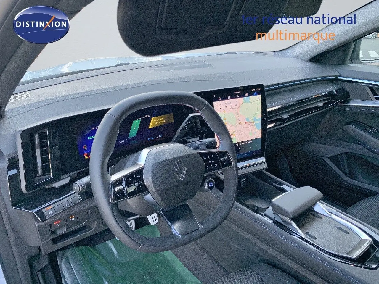 Intérieur du Renault Austral 2024 vu côté conducteur, tableau de bord noir avec écran tactile central et volant multifonction.