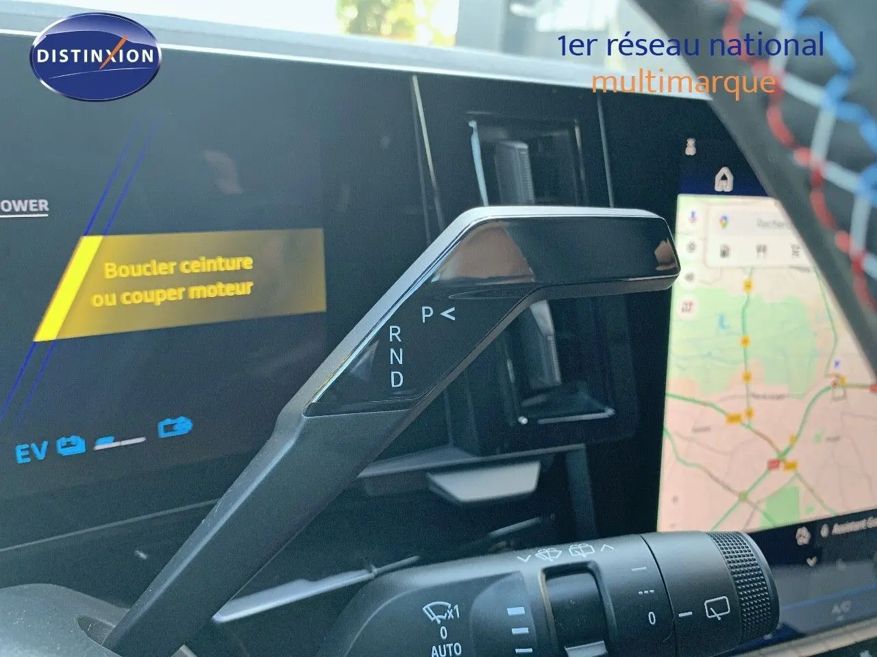 Le levier de vitesses automatique noir du Renault Austral 2024 en gros plan, avec l'écran tactile de navigation en arrière-plan.