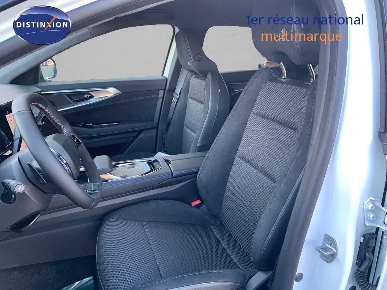 Intérieur côté conducteur du Renault Austral 2024 blanc métal, sièges noirs en cuir et alcantara avec surpiqûres bleues.