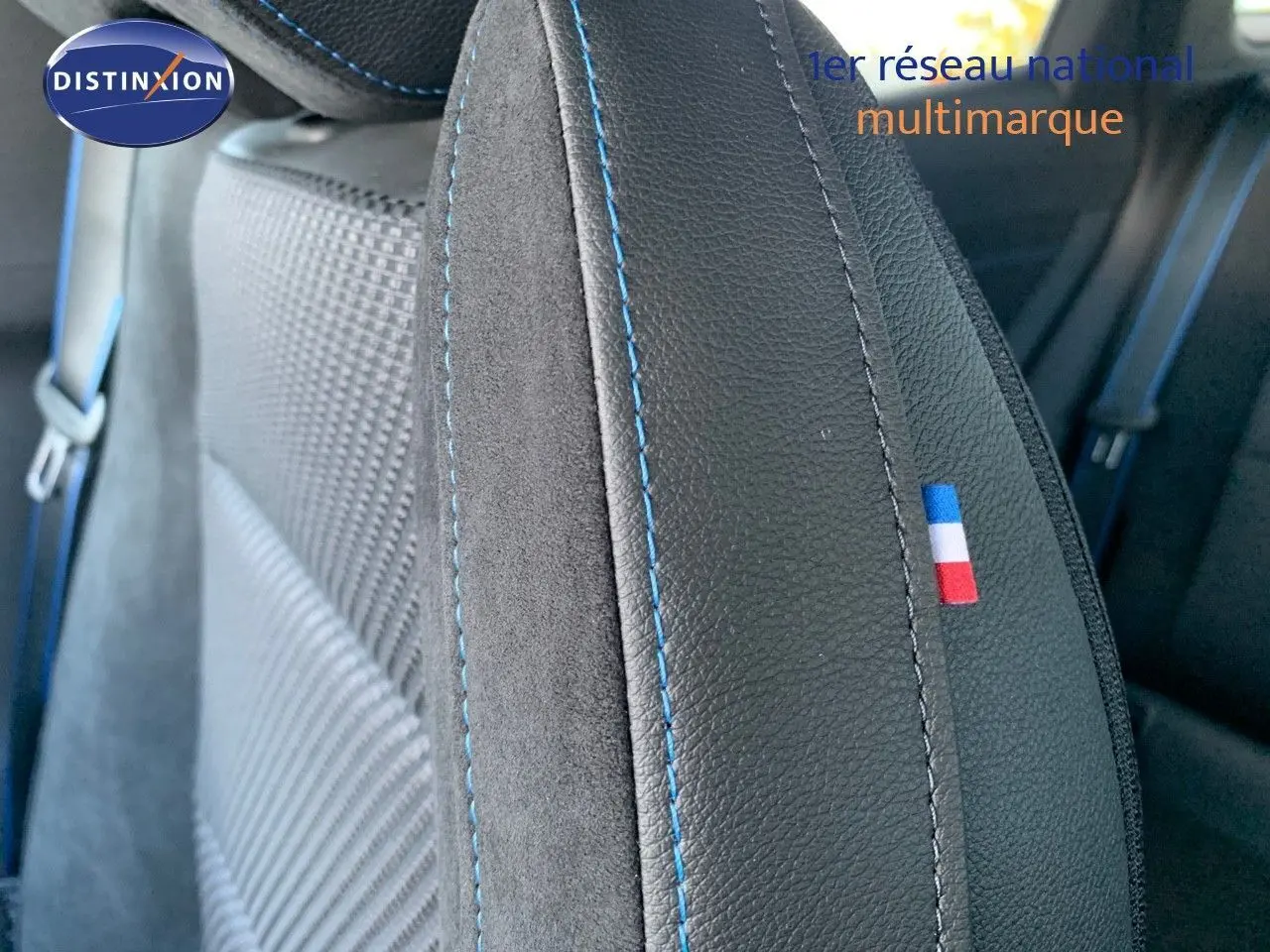 Gros plan sur le siège avant en cuir noir avec surpiqûres bleues et drapeau tricolore français du Renault Austral 2024.
