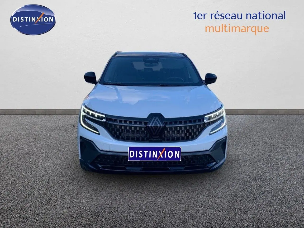 Vue frontale d'un Renault Austral blanc métal avec toit noir, mettant en valeur sa calandre et ses phares LED modernes.