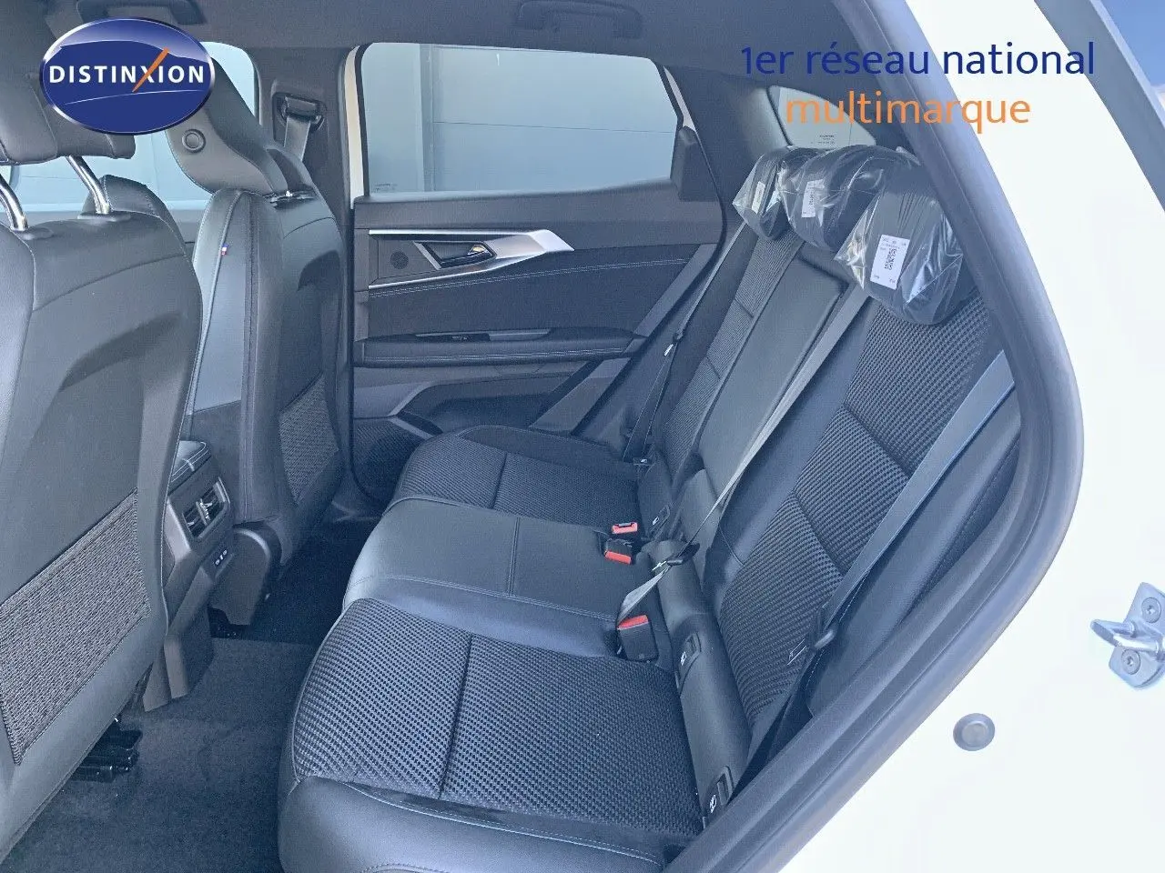 Vue latérale droite de l'habitacle arrière du Renault Austral 2024 blanc métal avec sièges noirs en cuir et tissu.