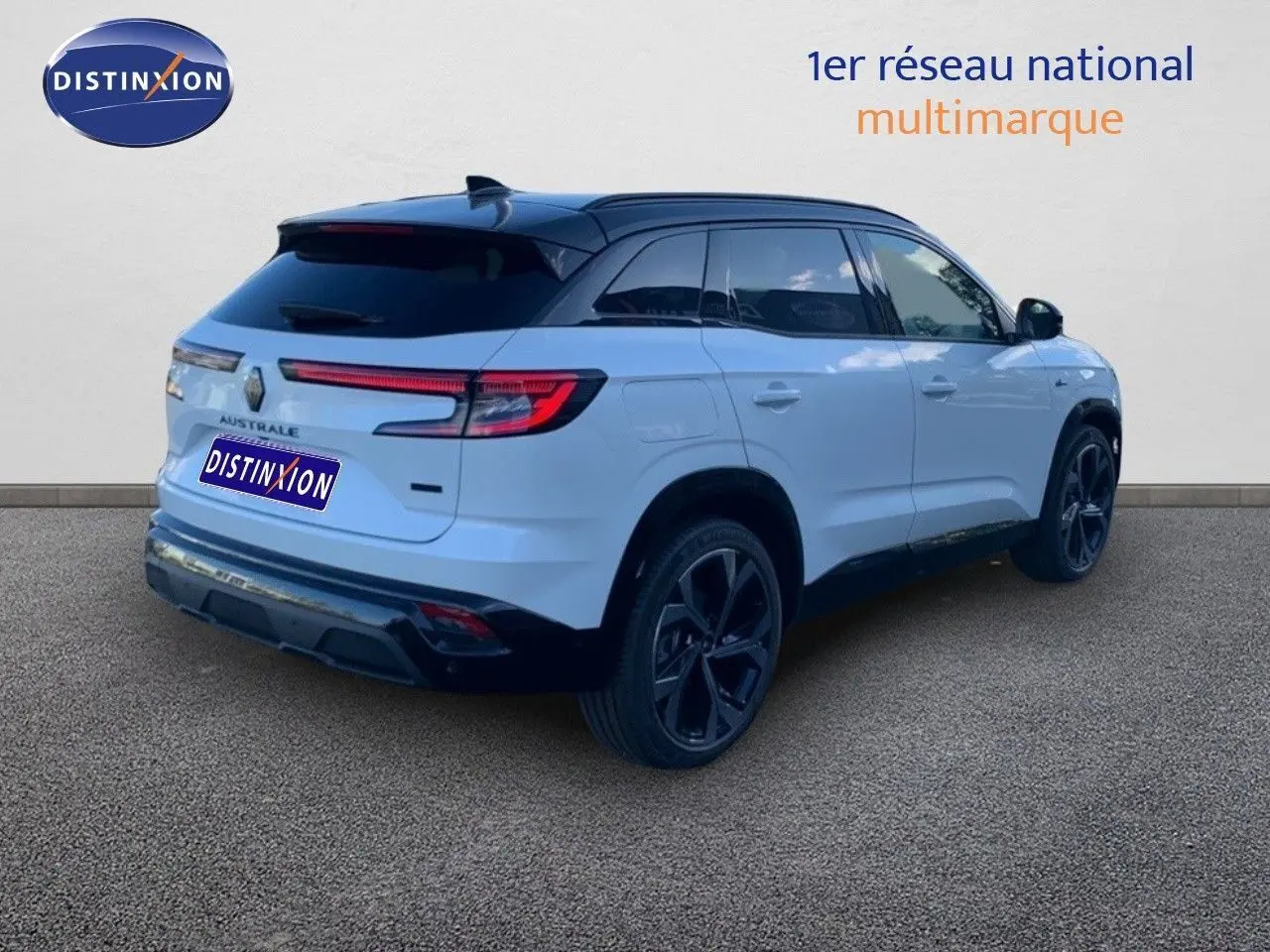 Vue 3/4 arrière droite du Renault Austral blanc métal avec toit noir et jantes noires sur fond neutre.