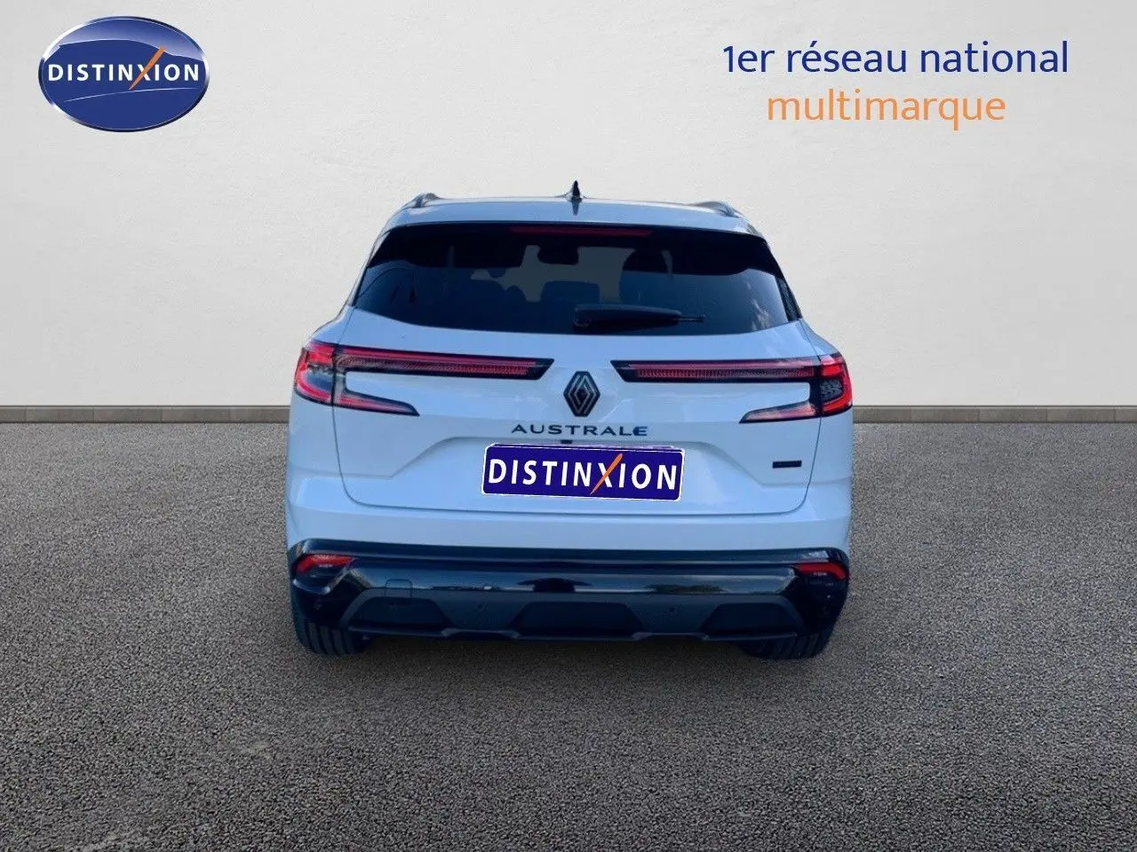 Vue arrière d'un Renault Austral blanc métal avec toit noir, mettant en valeur ses feux LED horizontaux et son badge distinctif.