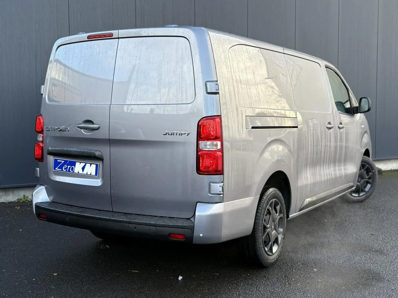 Vue 3/4 arrière droite du Citroën Jumpy XL gris Artense avec portes arrière battantes et jantes noires.