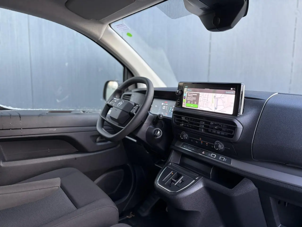 Vue intérieure côté conducteur du Citroën Jumpy XL gris Artense, avec tableau de bord moderne et écran GPS tactile.