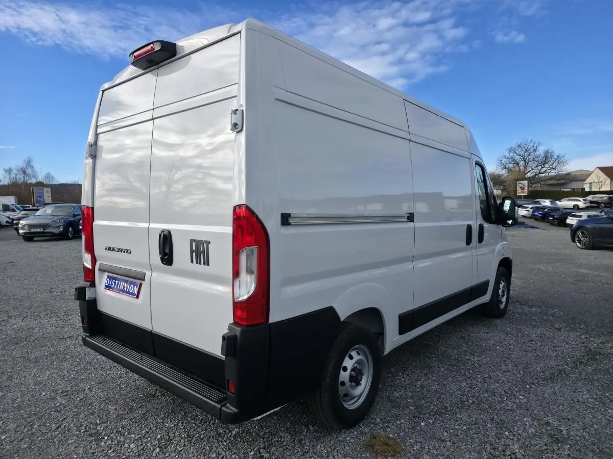 Vue 3/4 arrière droite d'un fourgon FIAT Ducato blanc tôlé avec portes arrière battantes et porte latérale coulissante.