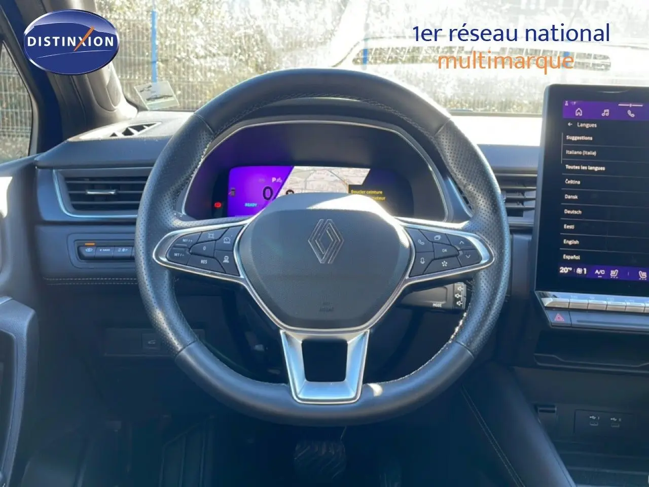 Vue intérieure centrée sur le volant noir perforé de la Renault Symbioz 2025 avec tableau de bord numérique et écran tactile.