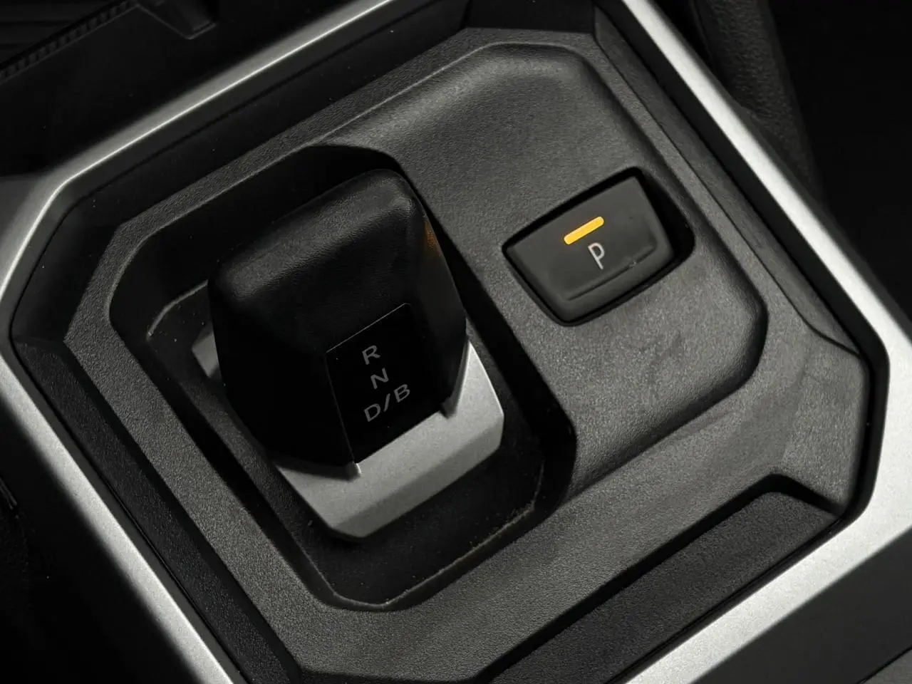 Gros plan sur la commande de boîte automatique noire et grise du Dacia Duster 2026, intérieur sobre et fonctionnel.