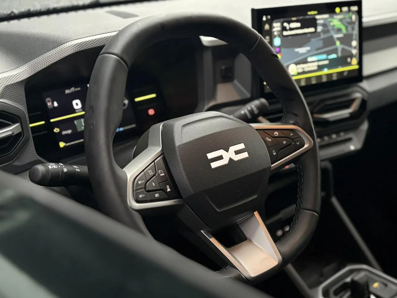 Vue rapprochée du volant multifonction et du tableau de bord digital du Dacia Duster 2026, intérieur moderne.