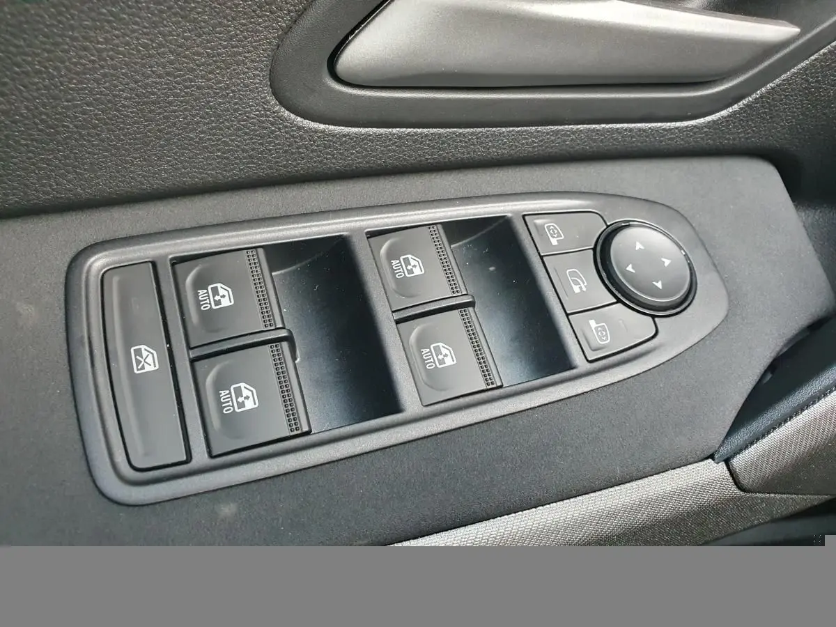 Gros plan sur les commandes de lève-vitres et rétroviseurs côté gauche intérieur du Dacia Bigster gris schiste 2026.