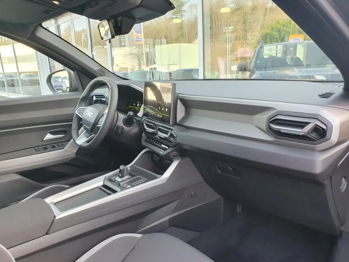 Vue intérieure côté conducteur du Dacia Bigster 2026, tableau de bord moderne avec écran tactile et volant multifonction.