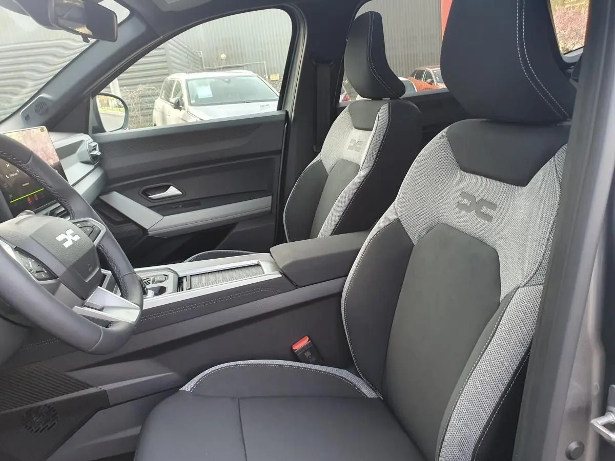 Intérieur de la Dacia Bigster 2026 en gris schiste, vue côté conducteur sur sièges sport bicolores et tableau de bord moderne.