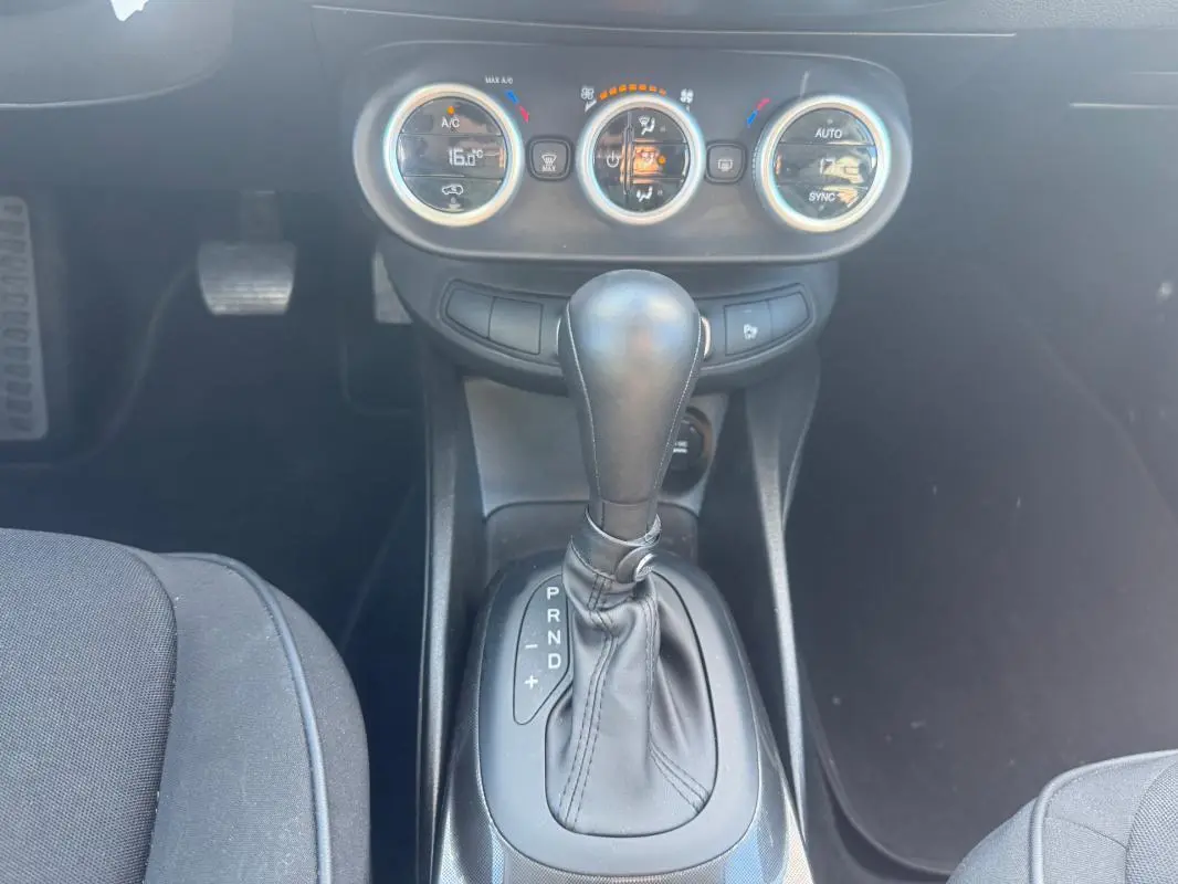 Vue intérieure centrée sur le levier de vitesse automatique et les commandes de climatisation d'une FIAT 500X MY23.